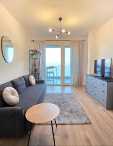 un soggiorno con un divano, una TV e un tavolo di Afi City - București Noi a Bucarest