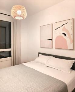 una camera con letto e luce a ciondolo di Afi City - București Noi a Bucarest