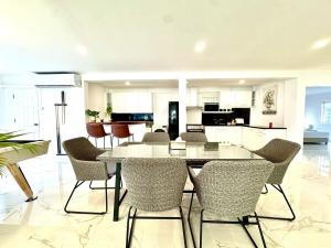 a dining room and kitchen with a table and chairs at Sunset Beach Villa 30m to Beach 4BR in North Pattaya +47 photos