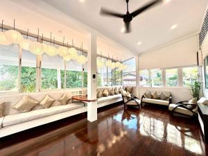 a living room with a long couch and windows at Sunset Beach Villa 30m to Beach 4BR in North Pattaya