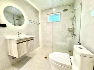a bathroom with a toilet and a sink and a mirror at Sunset Beach Villa 30m to Beach 4BR in North Pattaya