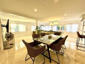 a dining room and living room with a table and chairs at Sunset Beach Villa 30m to Beach 4BR in North Pattaya