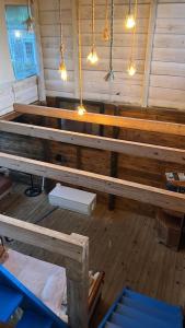 een grote houten bank in een kamer met verlichting bij Chalé da Joaquina in Florianópolis +3 foto's