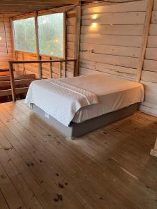 een slaapkamer met een bed in een blokhut bij Chalé da Joaquina in Florianópolis