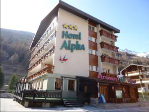 un edificio alpino de hotel con un cartel en Hotel Alpha, en Saas-Grund