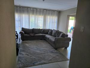 un soggiorno con un divano e un tappeto di 55 on 5th a Lichtenburg