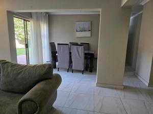un soggiorno con un divano e un tavolo con sedie di 55 on 5th a Lichtenburg
