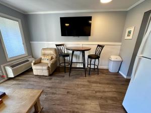 un salon avec une table, des chaises et une télévision dans l'établissement Seaside 155, à Île de Hilton-Head