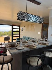 a kitchen with a table with plates and glasses on it at Cabañas Bello Atardecer in Constitución