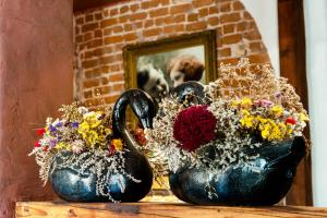 a vase filled with flowers on top of a wooden table at Hotel Justus in Rīga