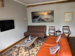 a living room with a couch and a table at Villa Keys in Wilderness +21 photos