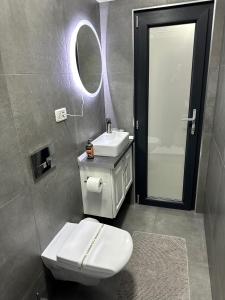 un bagno con un water, un lavandino e uno specchio di White Studio a Câmpulung Moldovenesc Altre 3 foto