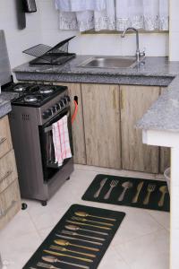 a kitchen with a stove and a sink and a counter at Kj suites in Meru