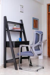 a desk with a blue chair next to a desk at Kj suites in Meru +5 photos