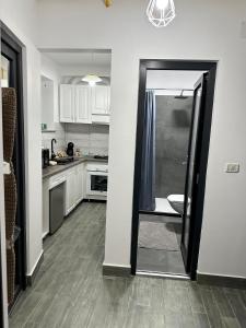 a kitchen with white cabinets and a door leading to a dining room at White Studio in Câmpulung Moldovenesc