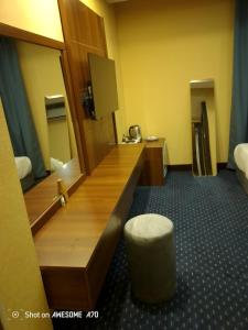 une chambre d'hôtel avec un comptoir de réception et un tabouret dans l'établissement رؤيا الفخامة luxury vision, à Al Khafji