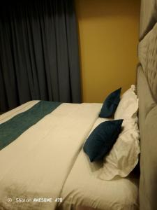 - un lit avec des oreillers bleus dans l'établissement رؤيا الفخامة luxury vision, à Al Khafji