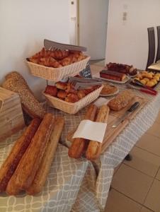a table topped with baskets of bread and pastries at BRIT HOTEL Le Lion d'Or CHINON in Chinon