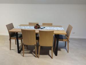 a wooden table with chairs and a flower arrangement on it at Casa Mont Blanc Cavnic apartament 2 in Cavnic