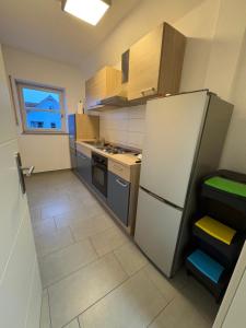 eine kleine Küche mit einem Kühlschrank und einem Fenster in der Unterkunft Großzügiges Design-Loft in Aulendorf in Niederdorla