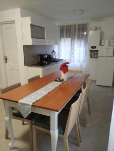 eine Küche mit einem Holztisch und weißen Schränken in der Unterkunft Casa Mont Blanc apartament 1 in Cavnic + 4 Fotos