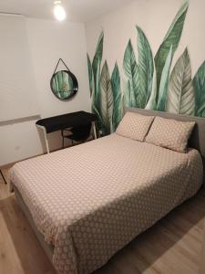 een slaapkamer met een bed en een plantenwand bij Petite Escale in Beaugency