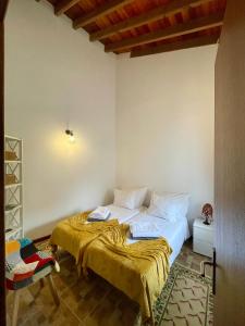 una camera da letto con un letto con una coperta gialla sopra di Santana Northeast a Feteira Grande Altre 20 foto