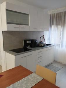 eine Küche mit weißen Schränken und einer schwarzen Arbeitsplatte in der Unterkunft Casa Mont Blanc apartament 1 in Cavnic