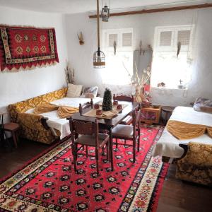 a living room with two beds and a table and chairs at Vila Kruna in Pirot