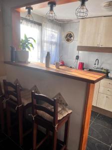 eine Küche mit einer Theke mit 2 Stühlen und einem Tisch in der Unterkunft Chuy home in Chuy