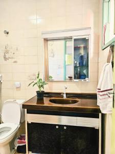 un bagno con lavandino, WC e finestra di Hostel La Casa de Mabel a Natal