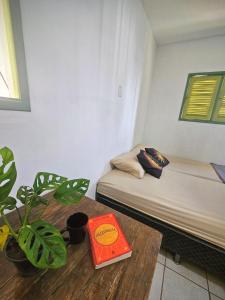 una stanza con un letto e un tavolo con un libro di Hostel La Casa de Mabel a Natal Altre 14 foto
