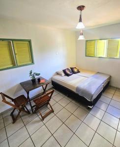 a bedroom with a bed and a table at Hostel La Casa de Mabel in Natal