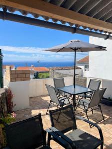 un patio con tavolo, sedie e ombrellone di Santana Northeast a Feteira Grande