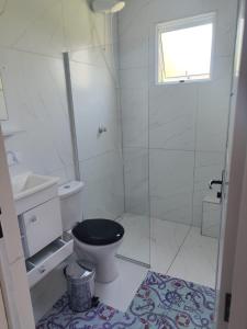 a bathroom with a black toilet and a shower at Casa Aconchegante in Bertioga +18 photos