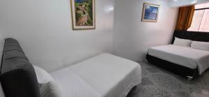 En eller flere senge i et værelse på Hostal Mónaco