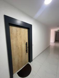 a wooden door in a room with a tile floor at Apartament in Ferizaj