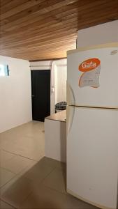 een keuken met een witte koelkast en een zwarte deur bij Habitaciones Monarcas in Villa Carlos Paz