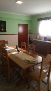 ein Esstisch mit Stühlen und ein Tisch mit Weinglas in der Unterkunft Casa Rosàlia in Castro Daire