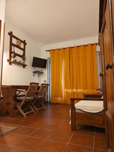a room with a table and chairs and a television at Appartamento Rialto Terminillo in Terminillo