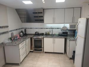 een kleine keuken met witte kasten en apparaten bij Verano Paz in Villa Carlos Paz