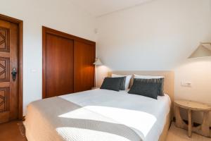 een slaapkamer met een groot wit bed en een tafel bij Dunéa - Oceanfront Luxury and Serenity - Ofir in Esposende