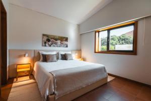 een slaapkamer met een groot bed en een raam bij Dunéa - Oceanfront Luxury and Serenity - Ofir in Esposende
