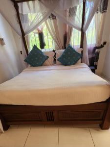 En eller flere senge i et værelse på Diani Gardens Cottage