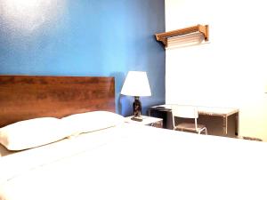 a bedroom with a bed and a table with a lamp at AVAION HOTEL LAX SoFi STADIUM in Inglewood
