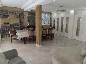 a dining room with a table and chairs and bookshelves at Gedera Rental in Gedera