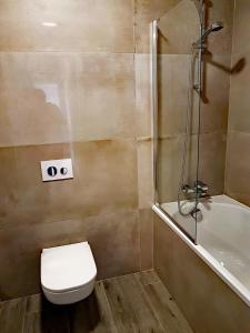 un baño con inodoro y ducha en CCH Elephant Apartments, en Poznan 27 fotos más