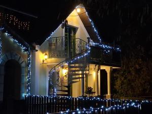 een huis met kerstverlichting aan de zijkant bij Vagabund Vendégház in Etyek