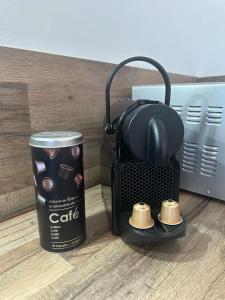 une cafetière avec une tasse de café et une boîte de café dans l'établissement Le Nid des Pistes, à Métabief