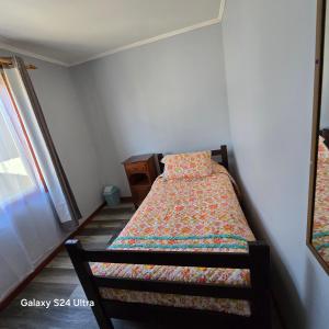 ein Schlafzimmer mit einem Bett mit einer Steppdecke darauf in der Unterkunft Casa en Frutillar in Frutillar